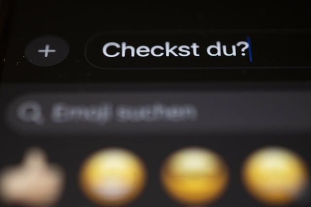 Die Worte „Checkst du?“ sind auf einem Smartphone zu sehen.