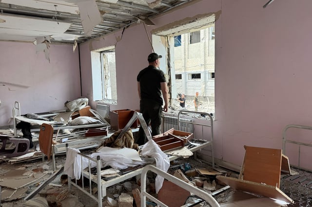 Un agente de la ley ucraniano mira por una ventana rota dentro de un edificio destruido de la colonia correccional de Bilenkivska tras un ataque aéreo en Bilenke, región de Zaporizhia, el 29 de julio de 2025, en medio de la invasión rusa de Ucrania