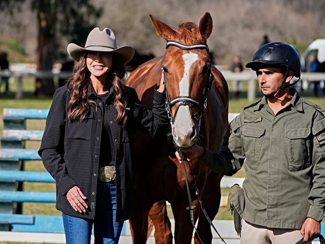 Argentina's Security Minister Patricia Bullrich (L) and US Homeland Security Secretary Kristi Noem (C) pose for a photo before getting horses during a visit to Campo de Mayo military base in San Miguel, Buenos Aires province, Argentina on July 28, 2025. Noem is on a diplomatic tour of several South American countries, with stops planned in Argentina, Chile, and Ecuador. (Photo by Alex Brandon / POOL / AFP)
