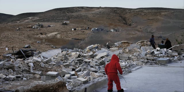 A young boy plays among rubble in No Other Land