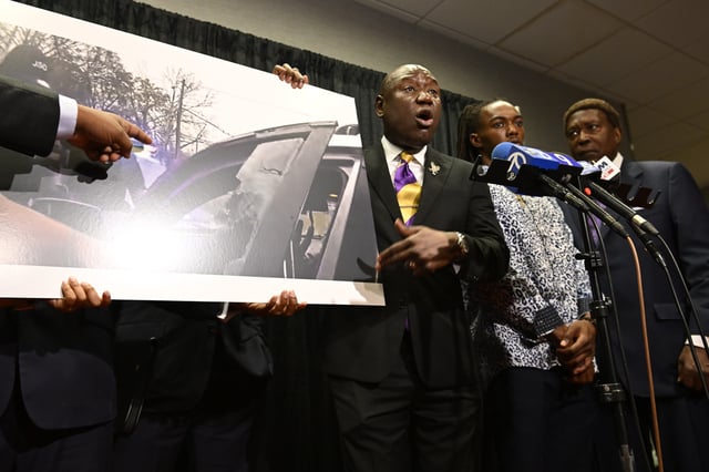 William McNeil Jr.'s attorney Ben Crump, center, speaks while showing a still from a police body cam video during a press conference Tuesday, July 29, 2025, in Chicago. (AP Photo/Paul Beaty)