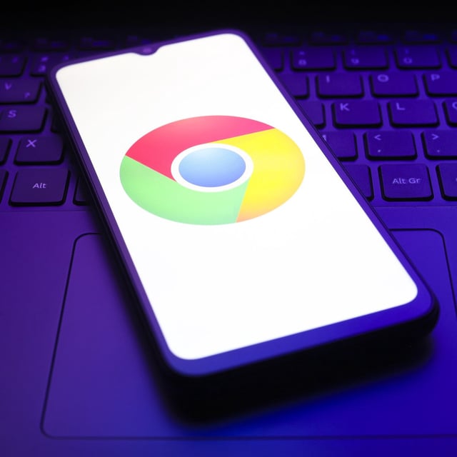 google chromo logo on phone, which is rested on a laptop