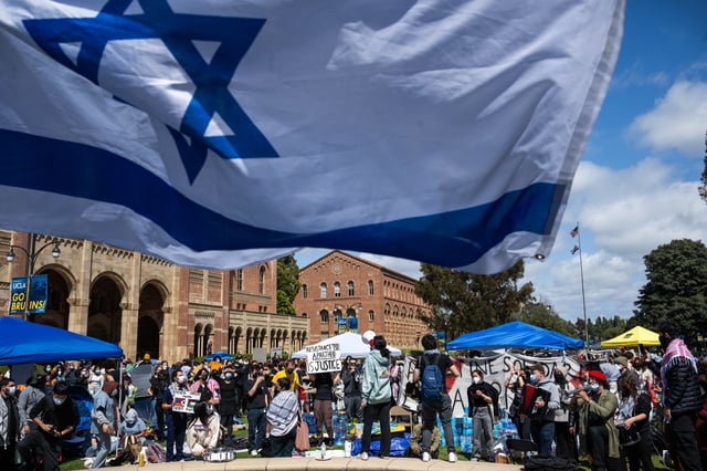 Los Angeles, CA – April 25:UCLA Jewish students waving Israeli flags counter-protest fellow students in their Palestinian solidarity camp on their Westwood campus on Thursday, April 25, 2024. College protests around the country are seeking their schools divestment in Israel over the Israel-Hamas war. (Photo by Sarah Reingewirtz/MediaNews Group/Los Angeles Daily News via Getty Images)