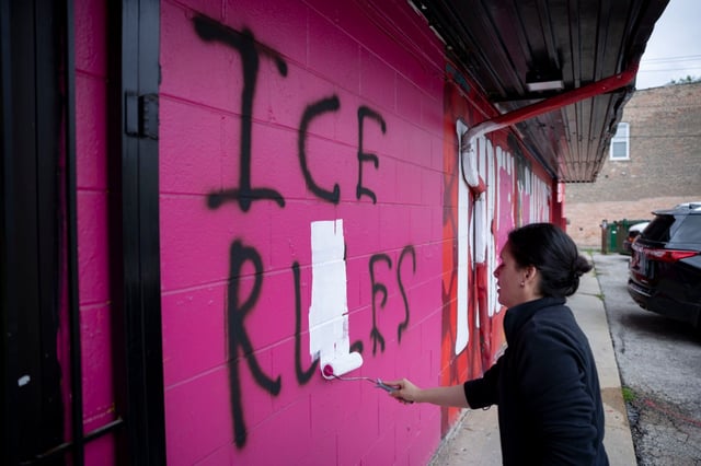 Bibiana Mesa paints over graffiti reading “ICE RULES” on July 20, 2025, after a vandal tagged their grocery store, La Fruteria, for the second night in a row in the 2700 block of West Cermak Avenue in the Little Village neighborhood of Chicago. (Brian Cassella/Chicago Tribune)