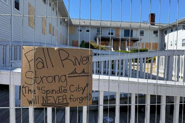 A handwritten sign is propped outside the Gabriel House on Tuesday, July 22, 2025, more than a week after a deadly fire at that assisted-living facility in Fall River, Mass. (AP Photo/Rodrique Ngowi)