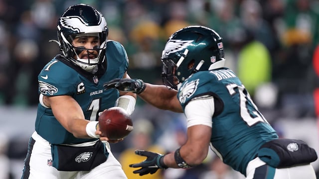 Jan 12, 2025; Philadelphia, Pennsylvania, USA; Philadelphia Eagles quarterback Jalen Hurts (1) hands the ball off to running back Saquon Barkley (26) during the third quarter in an NFC wild card game at Lincoln Financial Field. Mandatory Credit: Bill Streicher-Imagn Images