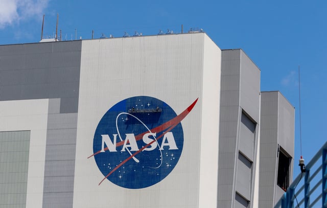 Workers pressure wash the logo of NASA on the Vehicle Assembly Building at the Kennedy Space Center in Cape Canaveral, Florida, U.S., May 19, 2020. REUTERS/Joe Skipper/File Photo