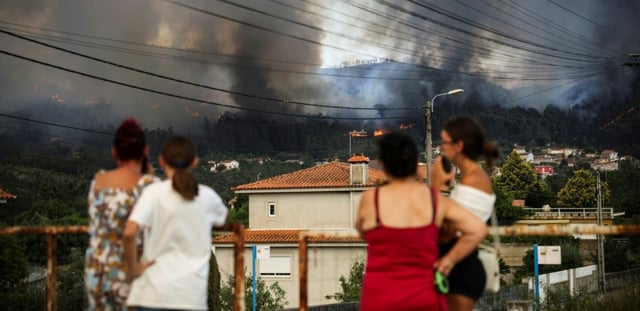 Des habitants surveillent un feu sur les collines entourant  Gondomar, dans le nord du Portugal, le 29 juillet 2025
