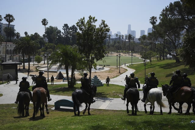 FILE - Federal agents ride on horseback at MacArthur Park Monday, July 7, 2025, in Los Angeles. (AP Photo/Damian Dovarganes,File)