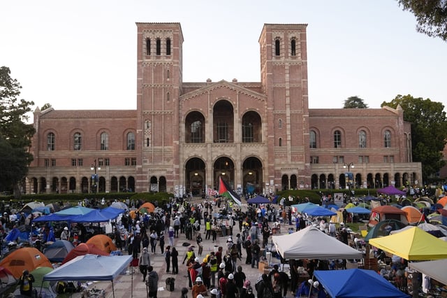 FILE - Demonstrators walk in an encampment on the UCLA campus after clashes between pro-Israel and pro-Palestinian groups, May 1, 2024, in Los Angeles. (AP Photo/Jae C. Hong, File)