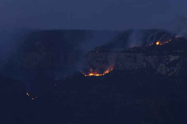 Smoke and fires rises at sunset from the Dragon Bravo fire at the Grand Canyon as seen from Mather Point near Grand Canyon Village, Ariz., Monday, July 28, 2025. (AP Photo/Jon Gambrell)