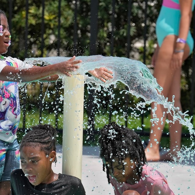 Children play in the water to avoid the heat at the Titusville Splash Pad, Tuesday, July 29, 2025, in Titusville, Fla. (AP Photo/Chris O'Meara)