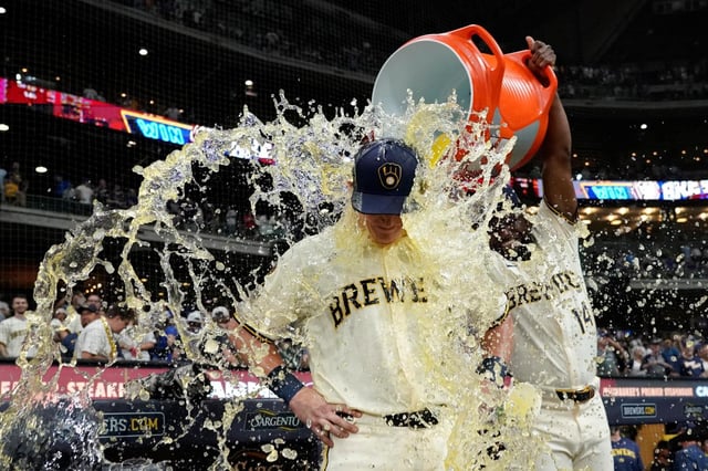 Andrew Vaughn de los Cerveceros de Milwaukeees bañado por el venezolano Andruw Monasterio tras la victoria ante los Cachorros de Chicago el martes 29 de julio del 2025. (AP Foto/Aaron Gash)