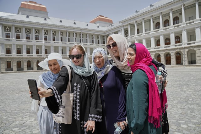 Zoe Stephens, 31, from Britain, takes a selfie with other foreign, female tourists and Maryam, a local trainee tour guide, at left, at Darul Aman Palace in Kabul, Afghanistan, Wednesday, May 28, 2025. (AP Photo/Ebrahim Noroozi)