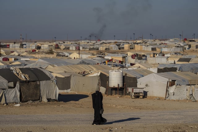 FILE - A woman walks in the al-Hol camp in northeastern Syria's Hasakeh province, where tens of thousands of mostly women and children linked to the Islamic State group have been living for years, Thursday, Jan. 30, 2025. (AP Photo/Bernat Armangue, File)