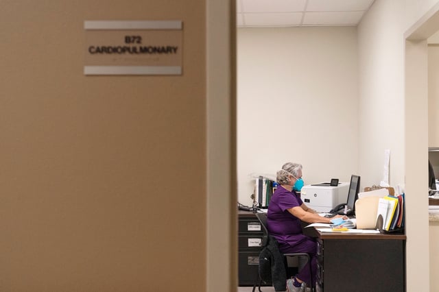 In this December 2020 photo, a respiratory therapist works on a computer in her office in Lamesa, Texas.