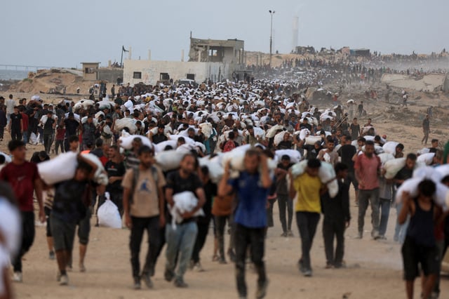 Palestinians carry aid supplies, that entered Gaza on trucks through Israel, in Beit Lahia, in the northern Gaza Strip July 29, 2025. REUTERS/Dawoud Abu Alkas/File Photo