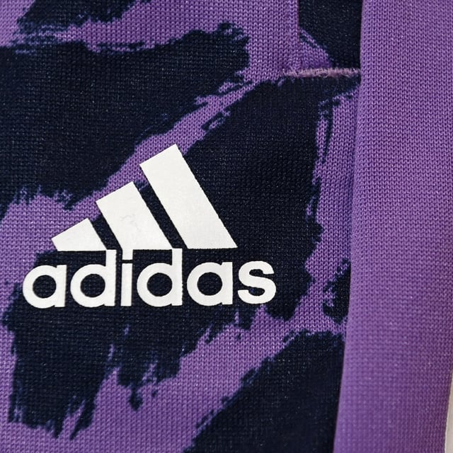 (FILES) The logo of the German sports equipment maker Adidas is pictured prior to the company's annual press conference in Herzogenaurach, southern Germany on March 8, 2023. German sportswear giant Adidas said on July 30, 2025 it took a hit from US tariffs in the second quarter but did not indicate whether it would pass on rising costs to consumers. The world's second-biggest sports outfitter said the levies introduced by US President Donald Trump had "a negative impact in the double-digit euro millions" between April and June, without giving a specific figure. US tariffs would also add around 200 million euros ($230 million) to Adidas's costs in the second half of the year, it said (Photo by Christof STACHE / AFP) (Photo by CHRISTOF STACHE/AFP via Getty Images)