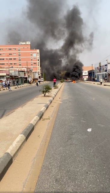 Smoke rises from a makeshit barricade blocking a road as people protest over a hike in the price of diesel, in Luanda, Angola, in this screengrab taken from a social media video, July 28, 2025. Portal Diamante Angola/via REUTERS/File Photo