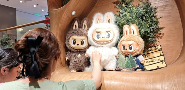 Des clients regardent des poupées Labubu dans un magasin Pop Mart à Shanghai, le 11 juin 2025