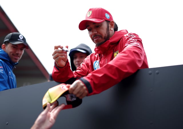 Lewis Hamilton of Great Britain and Scuderia Ferrari signs an autograph on the drivers parade prior to the F1 Grand Prix of Belgium at Circuit de Spa-Francorchamps on July 27, 2025 in Spa, Belgium.