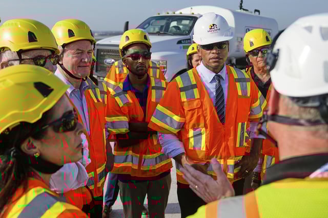 From center left, Sen. Chris Van Hollen, D-Md., Baltimore Mayor Brandon Scott and Maryland Gov. Wes Moore speak with representatives of the Maryland Transportation Authority during a tour of the demolition work zone for the remaining portions of the Francis Scott Key Bridge, Wednesday, July 30, 2025, in Baltimore. (AP Photo/Stephanie Scarbrough)