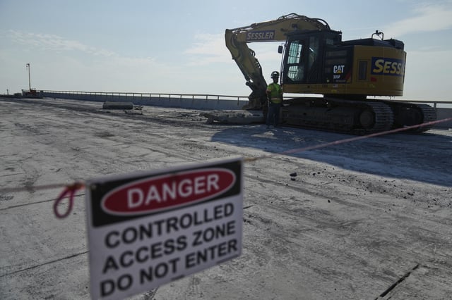 A demolition crew removes slabs of concrete from the remaining portions of the Francis Scott Key Bridge, Wednesday, July 30, 2025, in Baltimore. (AP Photo/Stephanie Scarbrough)
