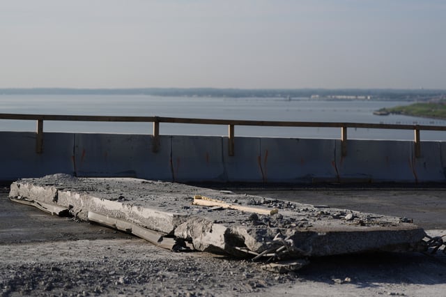 A slab of concrete is prepared to be removed from the remaining portions of the Francis Scott Key Bridge, Wednesday, July 30, 2025, in Baltimore. (AP Photo/Stephanie Scarbrough)