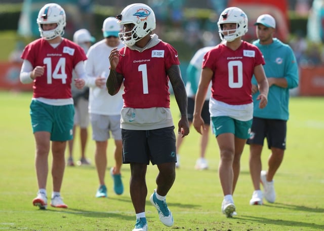 Miami Dolphins quarterbacks Quinn Ewers (14), Tua Tagovailoa (1) and Zach Wilson (0) walk on the field during practice at the NFL football team’s training camp, Saturday, July 26, 2025, in Miami Gardens, Fla. (AP Photo/Lynne Sladky)