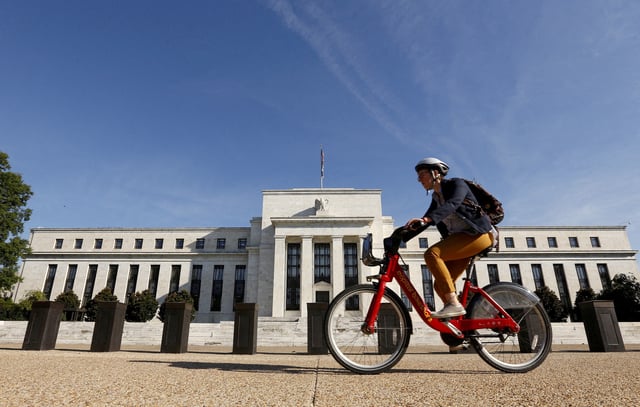 A cyclist passes the Federal Reserve headquarters in Washington September 16, 2015. REUTERS/Kevin Lamarque/File Photo