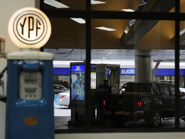 A worker fuels up a van at a YPF gas station in Buenos Aires, Argentina, Monday, July 14, 2025. (AP Photo/Rodrigo Abd)