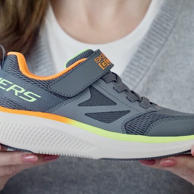 woman holding skechers sneaker with airtag holder