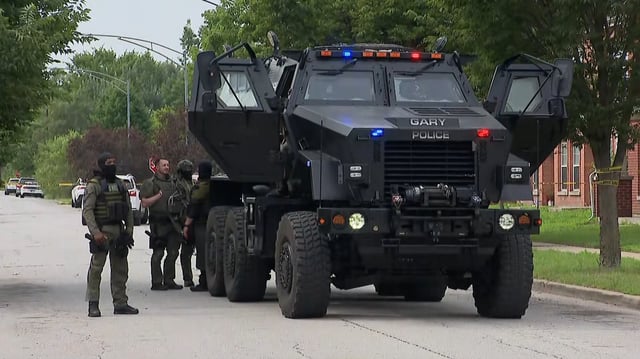 Police officers stand outside a SWAT vehicle in Gary, Indiana. 
