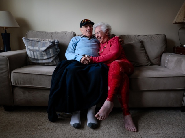 World War II veteran Morry Casso shares a laugh with his wife Niecy, while sitting for a portrait at their home. (Photo by Craig F. Walker/The Boston Globe via Getty Images)