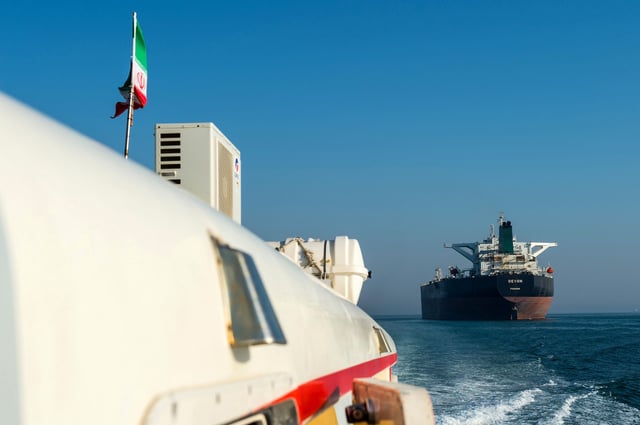 This 2018 photo shows a support vessel maneuvering a the crude oil tanker as it sails through the Persian Gulf to transport crude oil to export markets in Bandar Abbas, Iran.