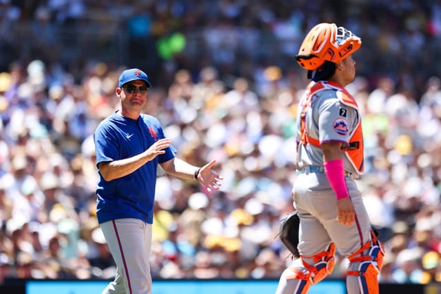 New York Mets manager Carlos Mendoza, left, reacts as he walks out to the mound to relieve starting pitcher Clay Holmes in the fourth inning of a baseball game against the San Diego Padres Wednesday, July 30, 2025, in San Diego. (AP Photo/Derrick Tuskan)