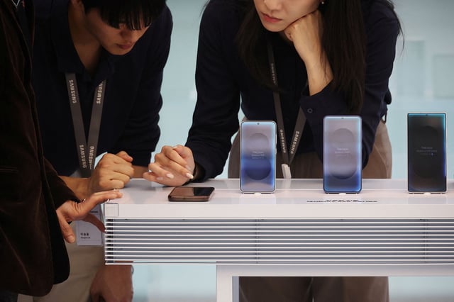 Samsung Electronics employees check the smartphone Galaxy S25 series at a Samsung store in Seoul, South Korea, April 15, 2025.