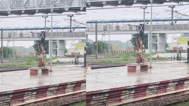 An elderly man does Sirsasana on a rainy railway platform.