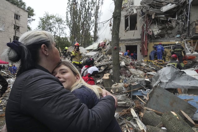 Women react outside a destroyed apartment building after a Russian missile attack in Kyiv, Ukraine, Thursday, July 31, 2025. (AP Photo/Efrem Lukatsky)