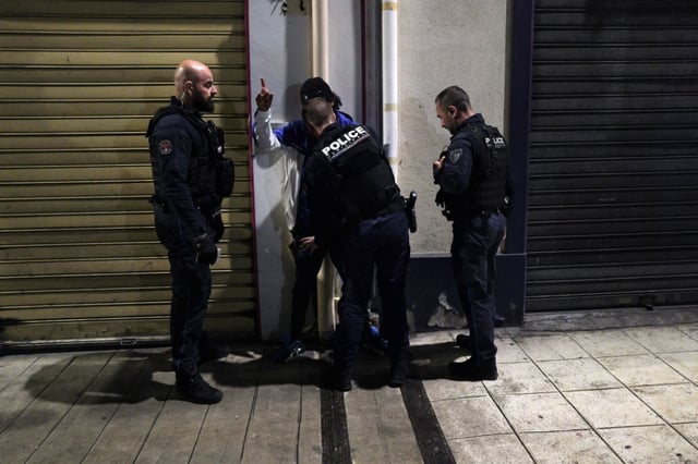 Des policiers municipaux contrôlent un jeune homme dans une rue de Nice alors placée sous couvre-feu nocturne pour les moins de 13 ans, le 2 avril 2024
