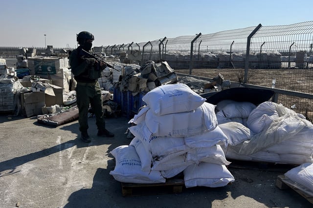 This photo taken during a tour with the Israeli military shows a an Israeli soldier stands guard next to humanitarian aid at the Kerem Shalom crossing between southern Israel and the Gaza Strip on July 27.