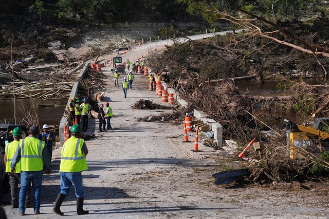 Crews work on the Cade Loop Bridge to clear debris after flooding along the Guadalupe River on Thursday, July 10, 2025, in Ingram, Texas.