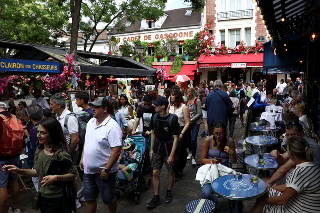 Tourists walk through crowded streets of the Place du Tertre in Montmartre, Paris, France, July 29, 2025. REUTERS/Tom Nicholson/File Photo