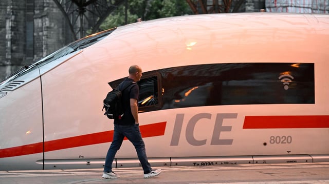 Ein Mann läuft an einem ICE-Zug der Deutschen Bahn vorbei