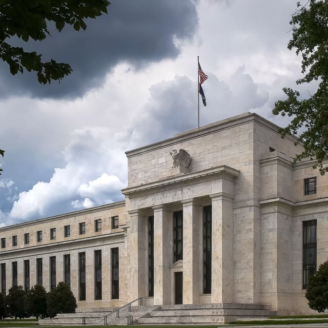 the federal reserve building in washington dc under gathering storm clouds