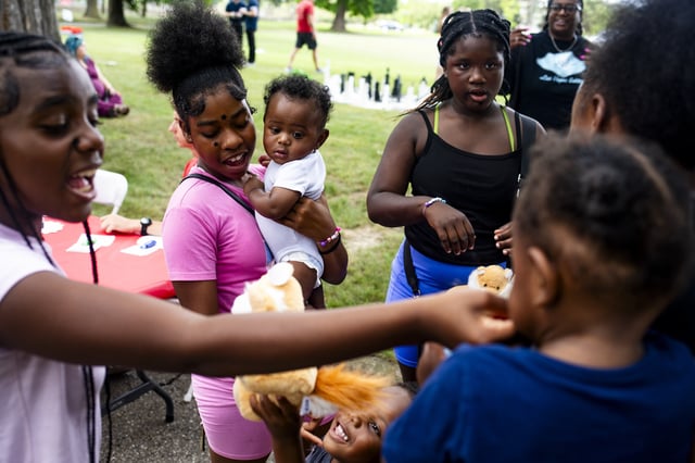 Trinity Wilson, 12, holds her five-month-old cousin, Jaylen, as she and her family walk around the Flint Rx Kids Baby Parade event on July 25, 2025 in on Applewood Campus in Flint, Michigan. The event celebrates the continued impact of Rx Kids on Flint families and babies. (AP Photo/Emily Elconin)
