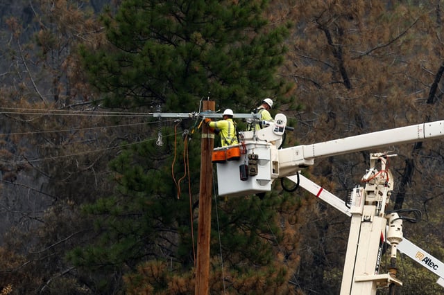 Pacific Gas and Electric (PG&E) crew work to restore power after the Park Fire burned through the area near Paynes Creek, in California, U.S. August 3, 2024. REUTERS/Fred Greaves