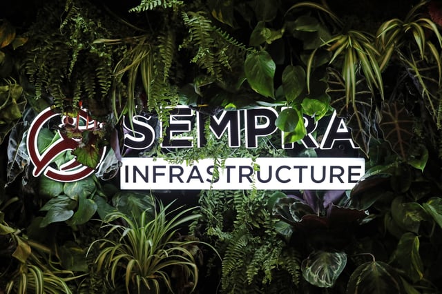 Plants surround the logo of energy infrastructure company Sempra Infrastructure during the LNG 2023 energy trade show in Vancouver, British Columbia, Canada, July 12, 2023. REUTERS/Chris Helgren/File Photo