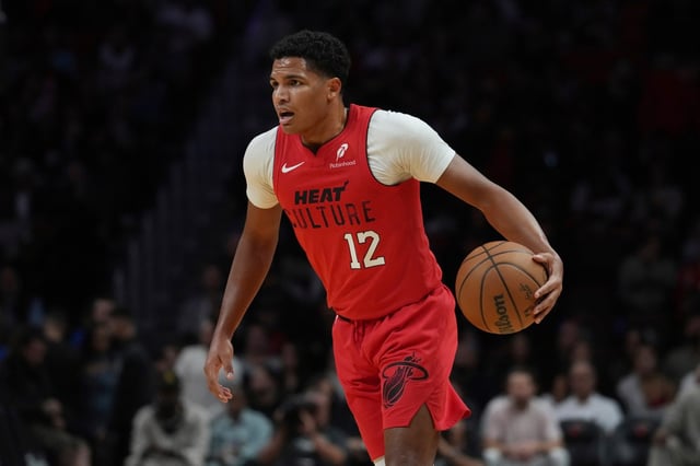 Miami Heat guard Dru Smith (12) dribbles the ball during the first half of an NBA basketball game against the Phoenix Suns, Saturday, Dec. 7, 2024, in Miami. (AP Photo/Marta Lavandier)