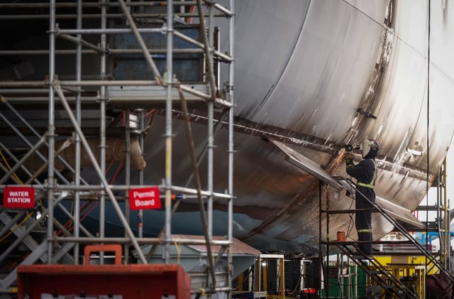 A worker uses an angle grinder on a vessel under construction at Seaspan Shipyards, in North Vancouver, B.C., on Thursday, October 10, 2024. THE CANADIAN PRESS/Darryl Dyck